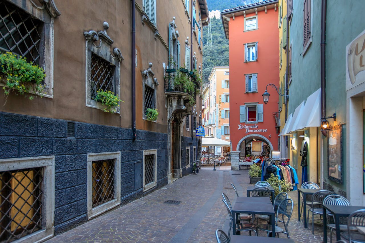Explore a picturesque alley in Veneto, Italy, featuring a quaint street cafe and vibrant shops.